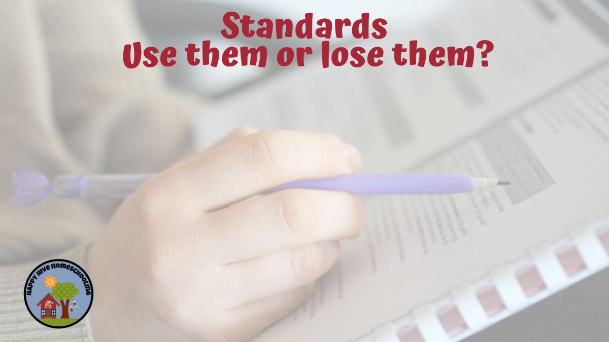 A hand holding a purple pen over a worksheet. Text reads, "Standards Use them or lose them?" with a logo in the corner.