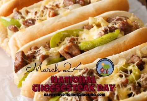 Four cheesesteak sandwiches with green peppers and onions on a wooden surface, with text reading "March 24 NATIONAL CHEESESTEAK DAY."